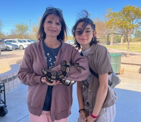 Veterinary Science teacher Jessica Berger and ISAZ student Linda Hernandez check out a slithery special guest at Family Fun Day.